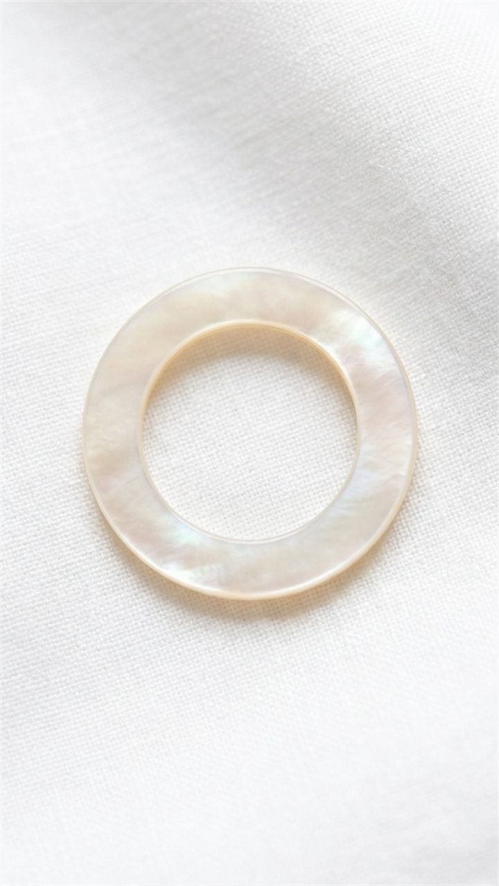 El anillo de OpenSyntheAI en nácar sobre lino blanco